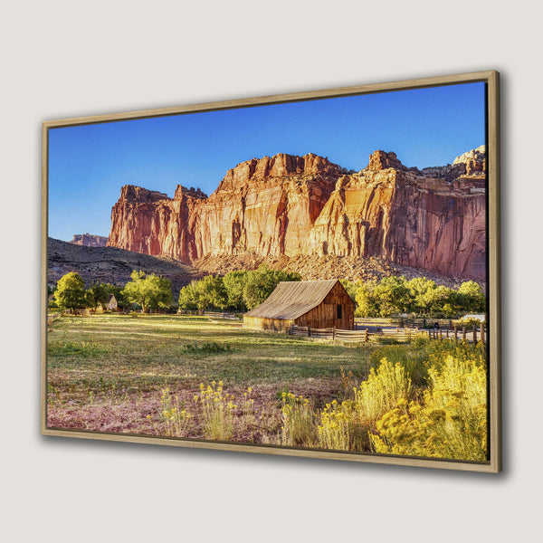 Framed Wall Art of a scenic desert landscape with a barn, featuring warm earth tones and a blue sky. Perfect for rustic decor.