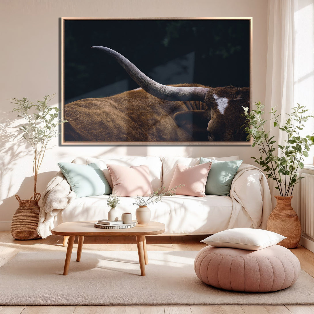 Framed Wall Art featuring a longhorn bull in a dark, moody style. Earthy tones with pops of pink and blue in a cozy living room setting.