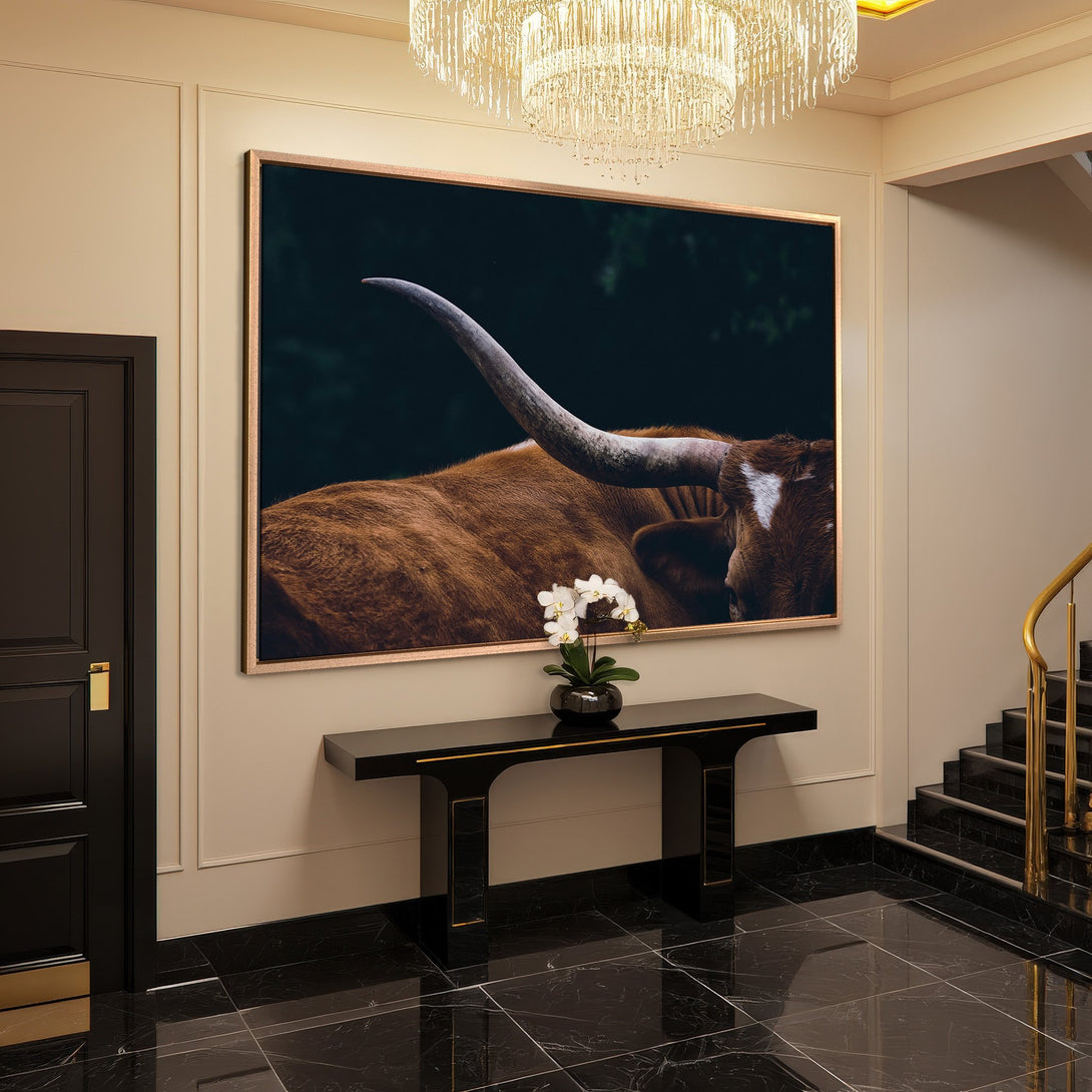 Framed Wall Art: Majestic longhorn canvas print in a luxurious entryway, featuring warm brown tones and a dark, moody backdrop. Elevate your space!