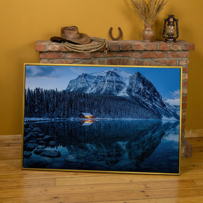 Lake Louise Winter Canvas with Lit Cabin and Mountain Reflection in yellow gold floating frame