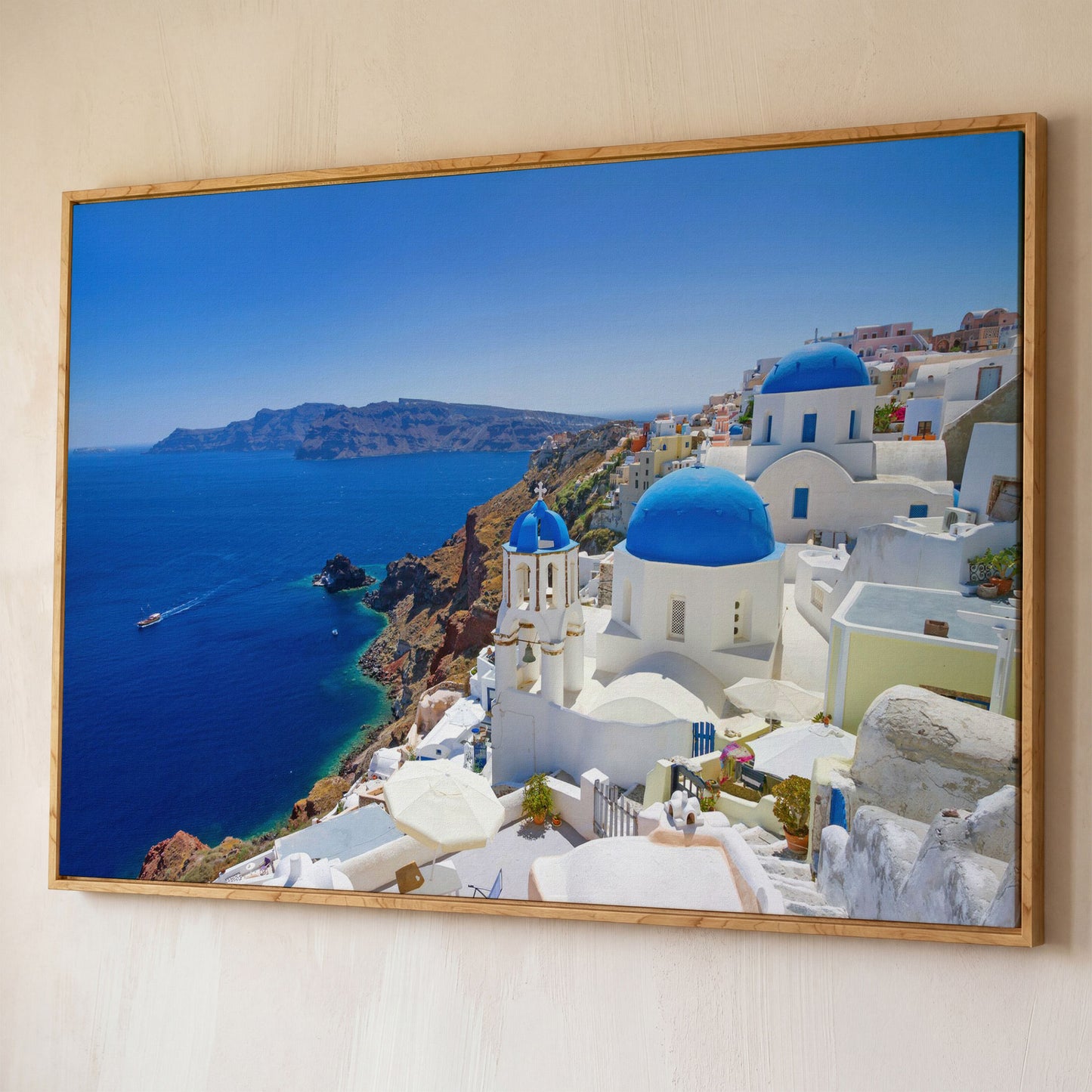 Santorini Island Canvas Print with Blue Domes shown in white oak floating frame