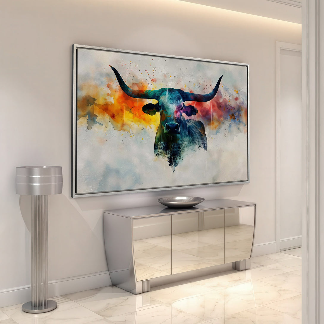 Framed Wall Art: Watercolor bull canvas print with vibrant blues, oranges, and yellows. Modern art for home decor, displayed in a stylish interior.