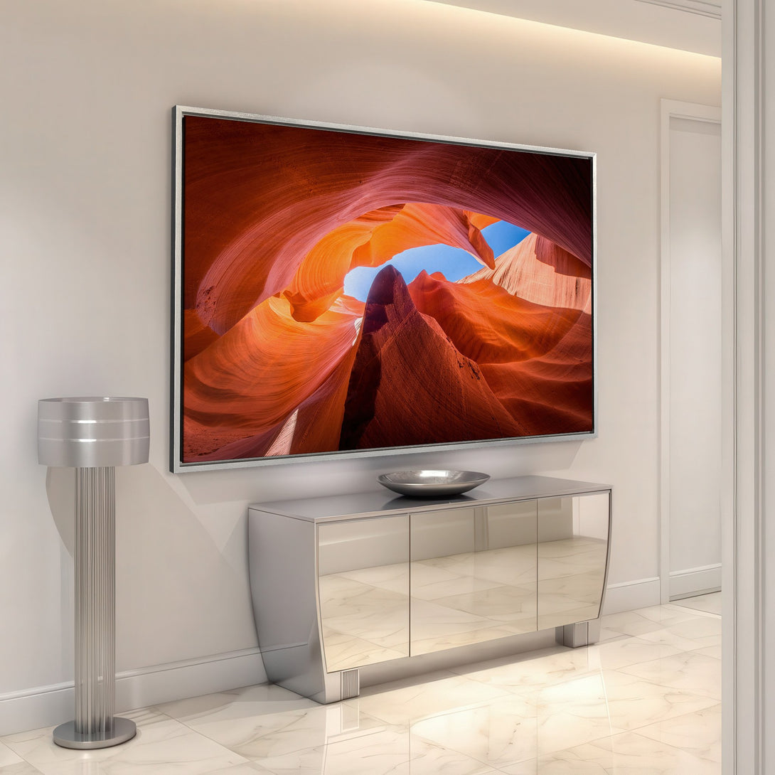 Framed Wall Art showcasing a stunning canyon landscape in warm orange and red tones. Modern interior design with a vibrant Canvas Print centerpiece.