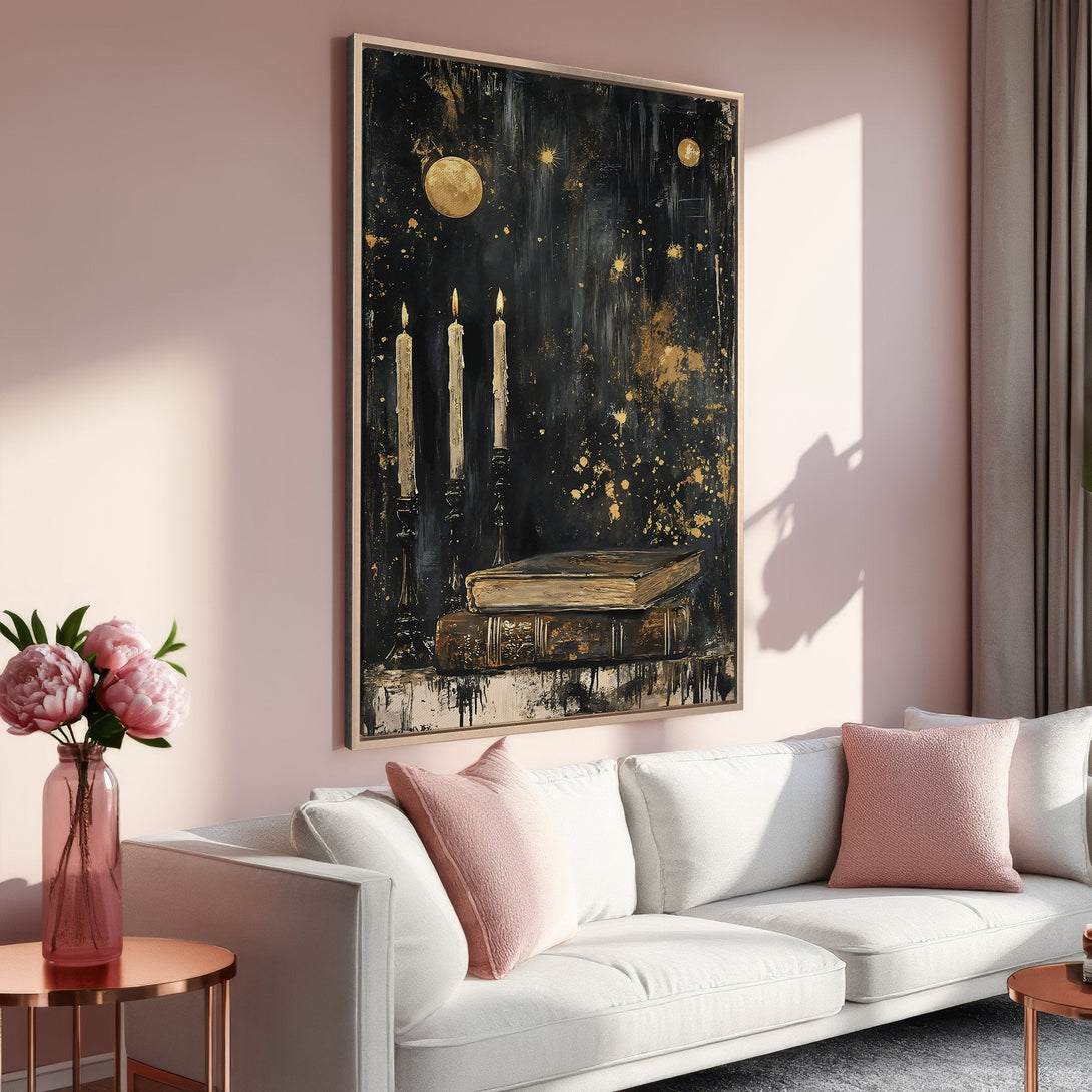 Framed Wall Art: Celestial candle and book painting in black and gold, displayed in a stylish living room with pink and white accents.