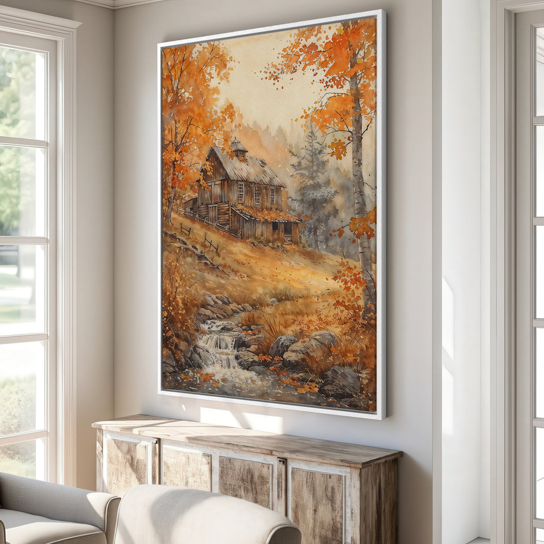 Framed Wall Art featuring a watercolor landscape of a cabin in autumn. Warm orange, brown, and gold hues create a cozy, inviting atmosphere. Perfect for home decor.