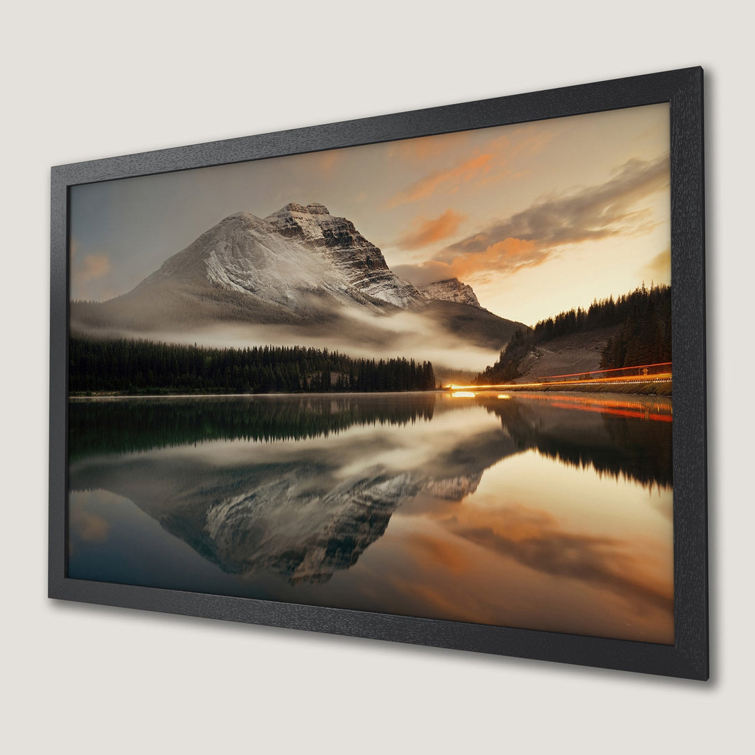Framed Poster of a stunning mountain landscape. Features a serene lake, and warm sunset hues. Perfect wall art for any space.