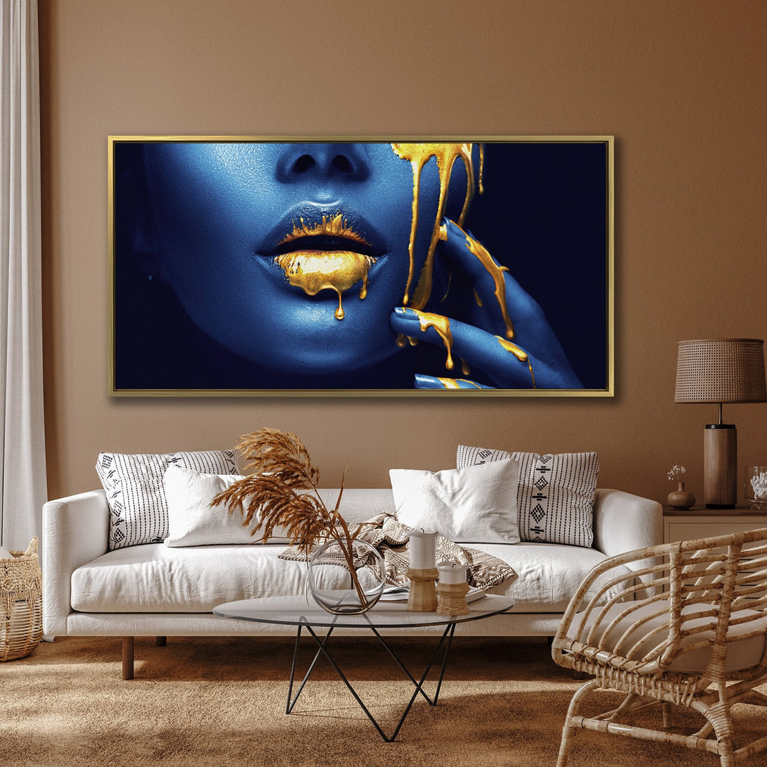 Canvas Print: Abstract art featuring a woman's face with blue skin and gold paint. Modern wall art with a striking blue and gold color palette.