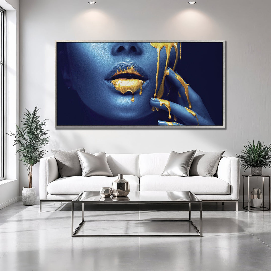 Framed Wall Art: Abstract portrait with blue skin and gold paint drips. Modern art piece in a luxurious interior, featuring a striking blue and gold color palette.