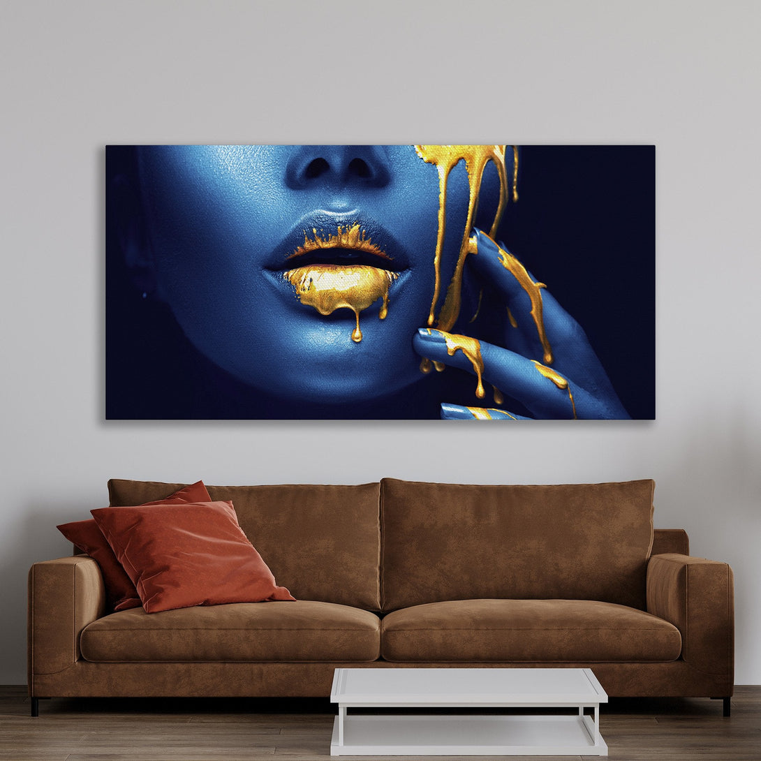 Framed Wall Art featuring a blue-toned face with gold dripping details. Modern art piece in a warm, inviting interior. Elevate your space with this stunning canvas print.