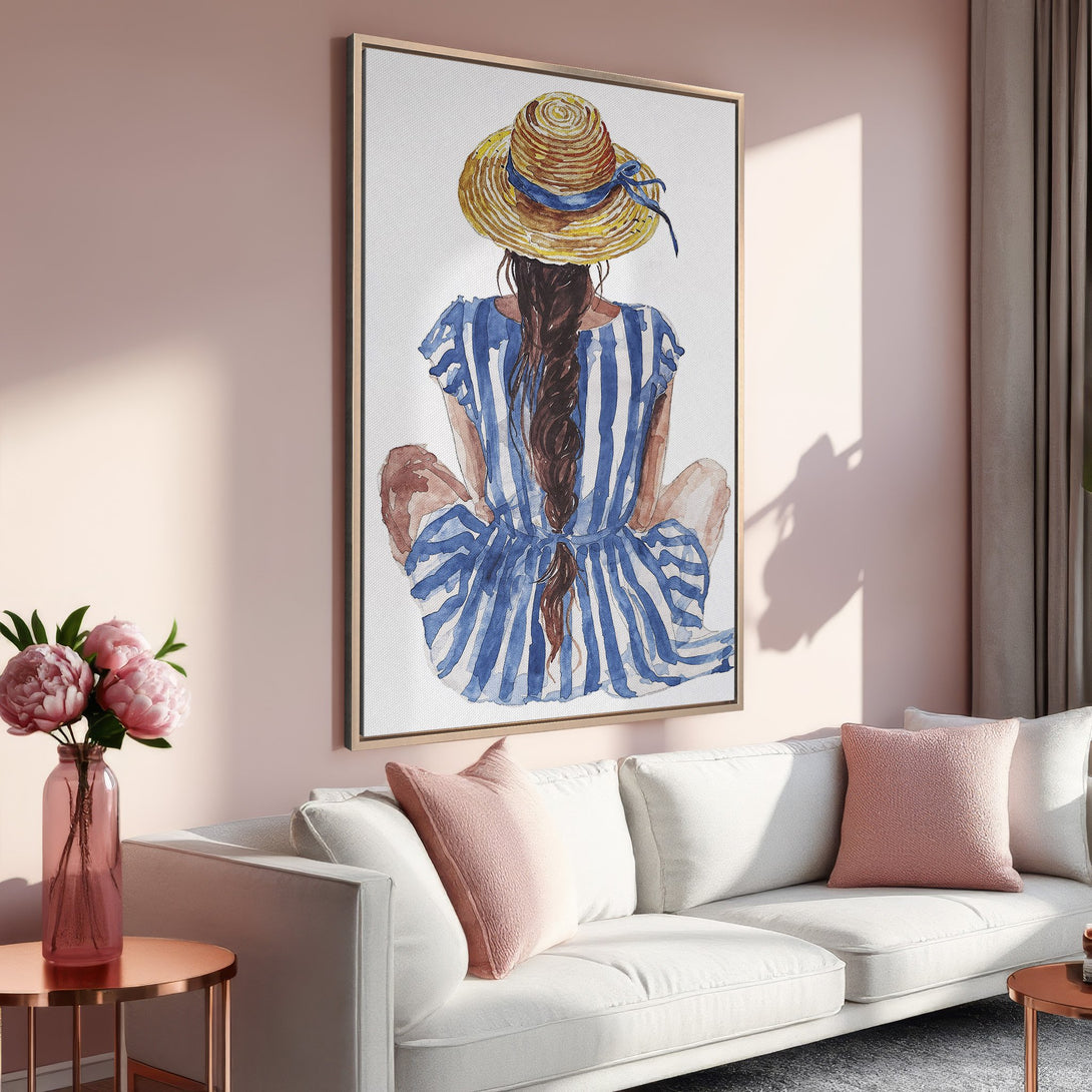 Framed Wall Art featuring a watercolor painting of a woman in a hat and striped dress. Soft color palette with blues, yellows, and pinks. Perfect for home decor.