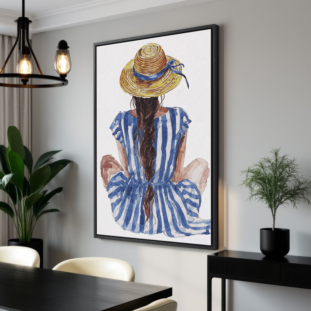 Framed Wall Art featuring a watercolor illustration of a woman in a striped dress and straw hat. Coastal style with blue, yellow, and brown tones. Perfect for home decor.