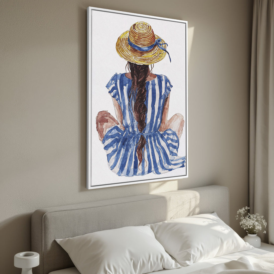 Framed Wall Art featuring a watercolor illustration of a woman in a straw hat and blue dress. Coastal style with a blue, brown, and white color palette.