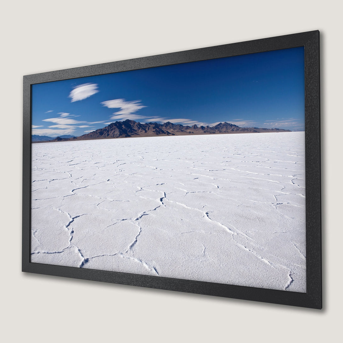 Framed Poster of desert landscape with blue sky, white salt flats, and mountains. Earthy tones.