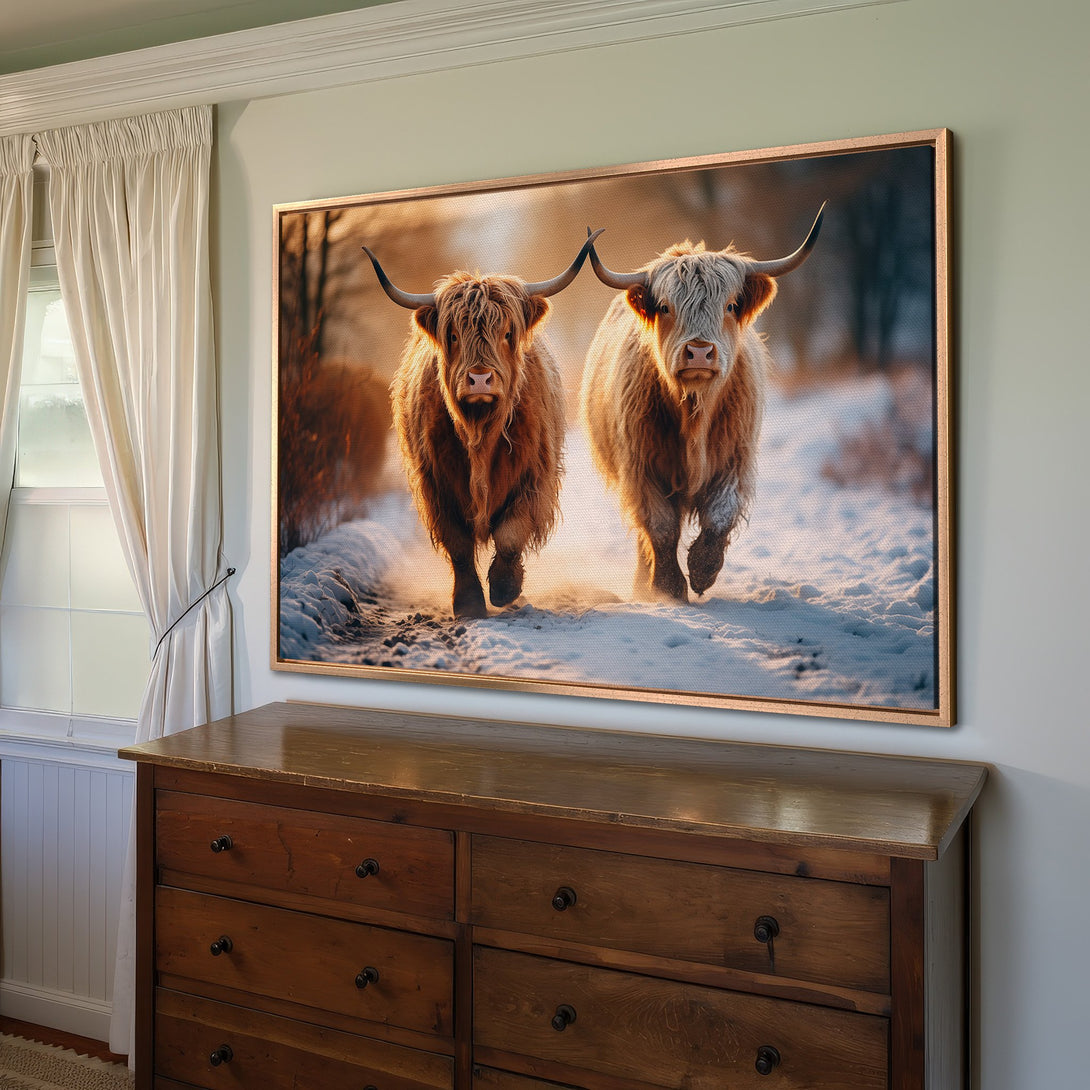 Framed Wall Art featuring two Highland cows in a snowy landscape. Warm, earthy tones create a rustic, inviting feel for your home decor.