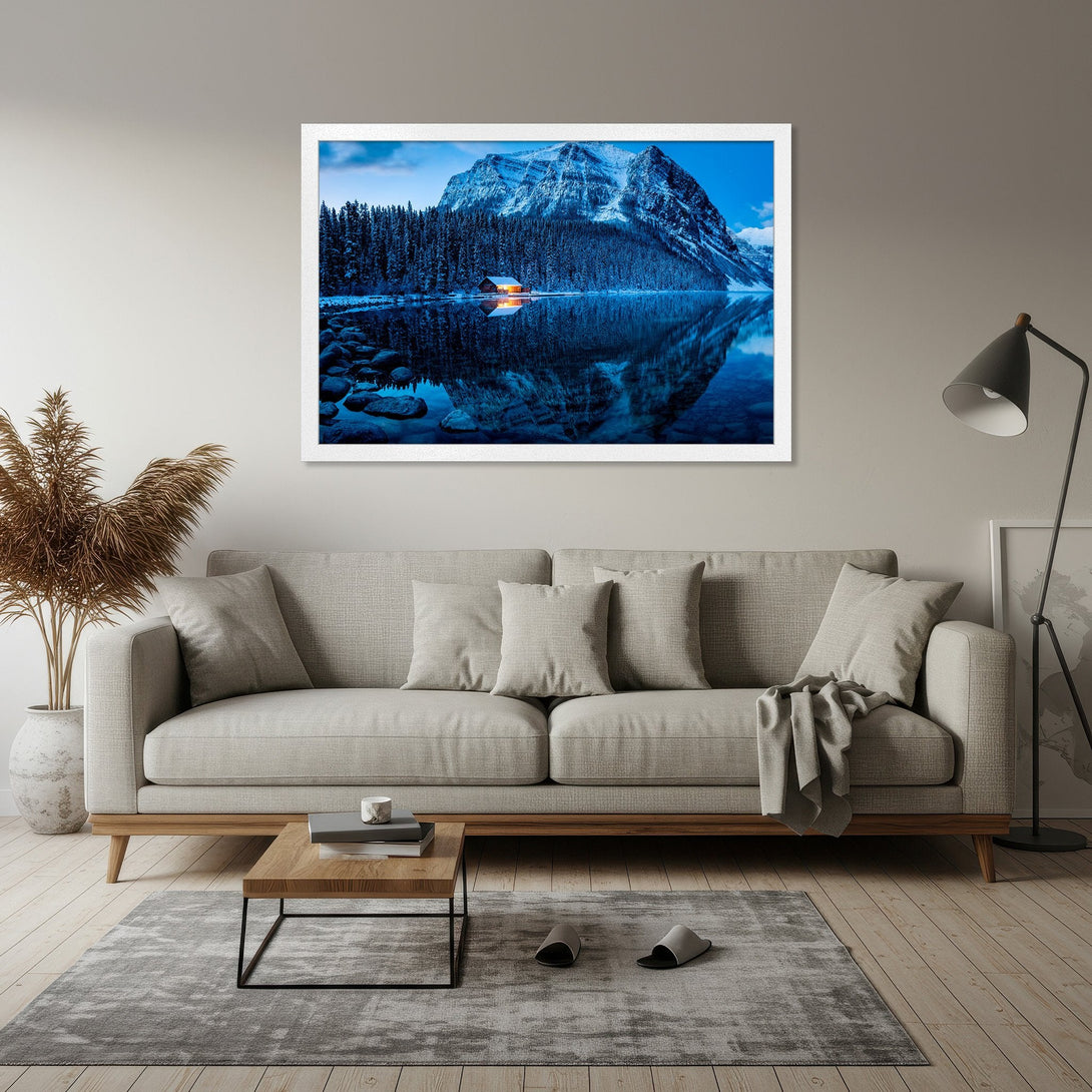 Framed Poster of a serene mountain lake scene. Cool blue tones and a cozy cabin create a calming aesthetic. Perfect wall art for your home!