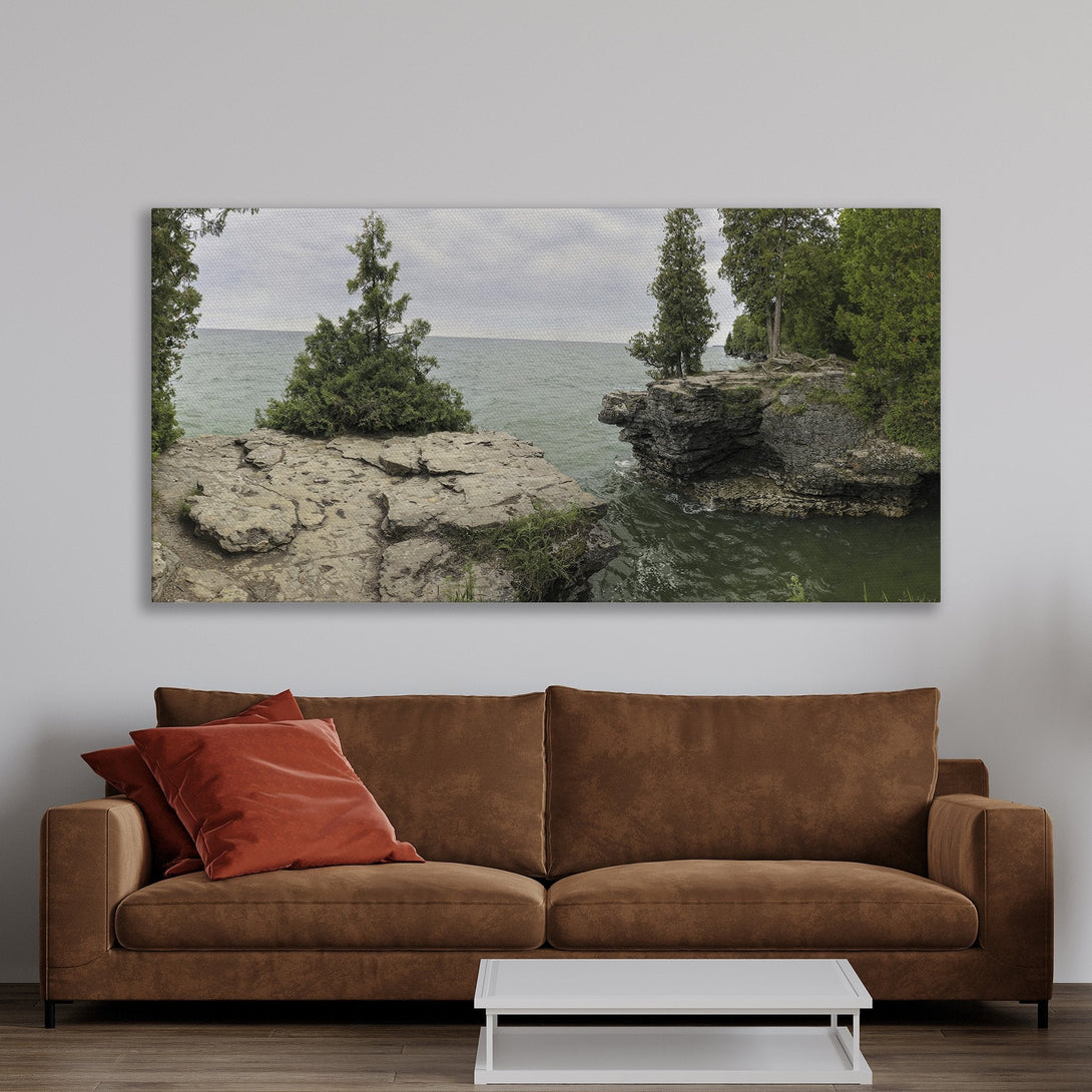 Framed Wall Art: Coastal landscape Canvas Print with green and gray tones, displayed in a warm, inviting living room setting. Perfect for adding a touch of nature!