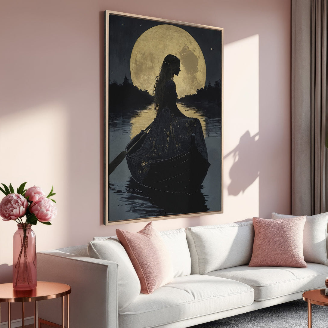 Framed Wall Art: Silhouette of a woman in a boat under a golden moon. Dramatic, moody artwork in black, gold, and blush tones. Perfect for a serene living room.