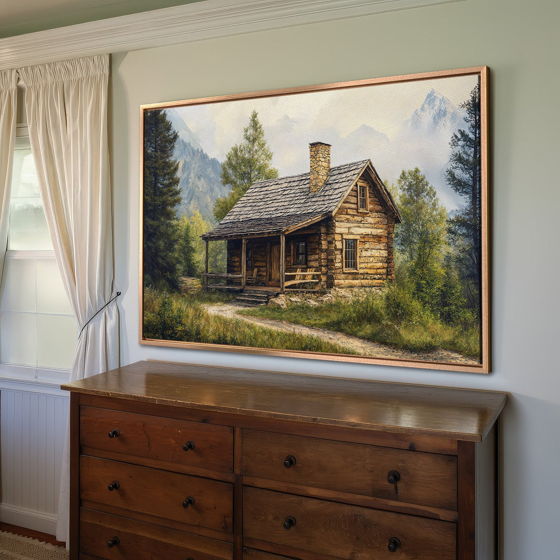 Framed Wall Art featuring a rustic cabin scene in a mountain landscape. Earthy tones and a cozy, inviting style perfect for home decor.