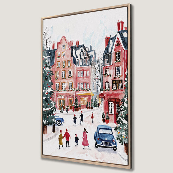 Framed Wall Art of a charming winter street scene in watercolor style. Features pink buildings, blue cars, and a festive red and green color palette.