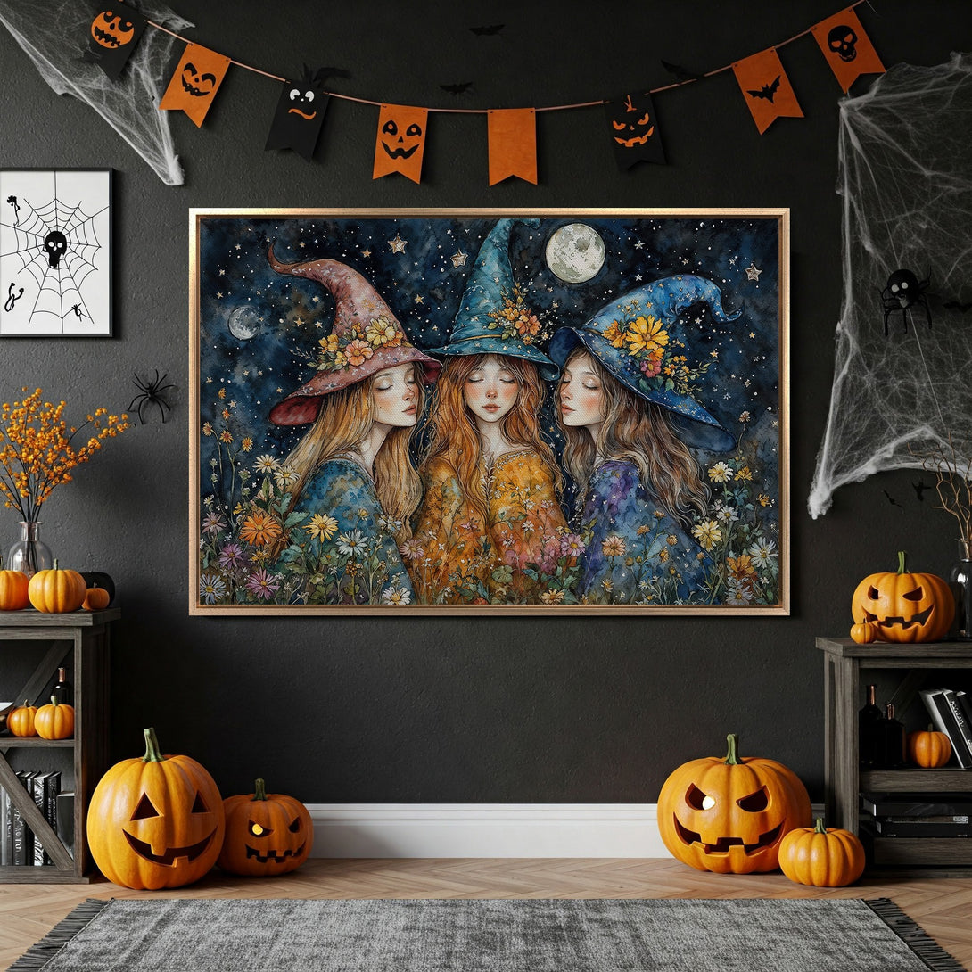 Framed Wall Art featuring three watercolor witches in a starry night scene. Beautiful blue, orange, and floral hues. Perfect Halloween decor!