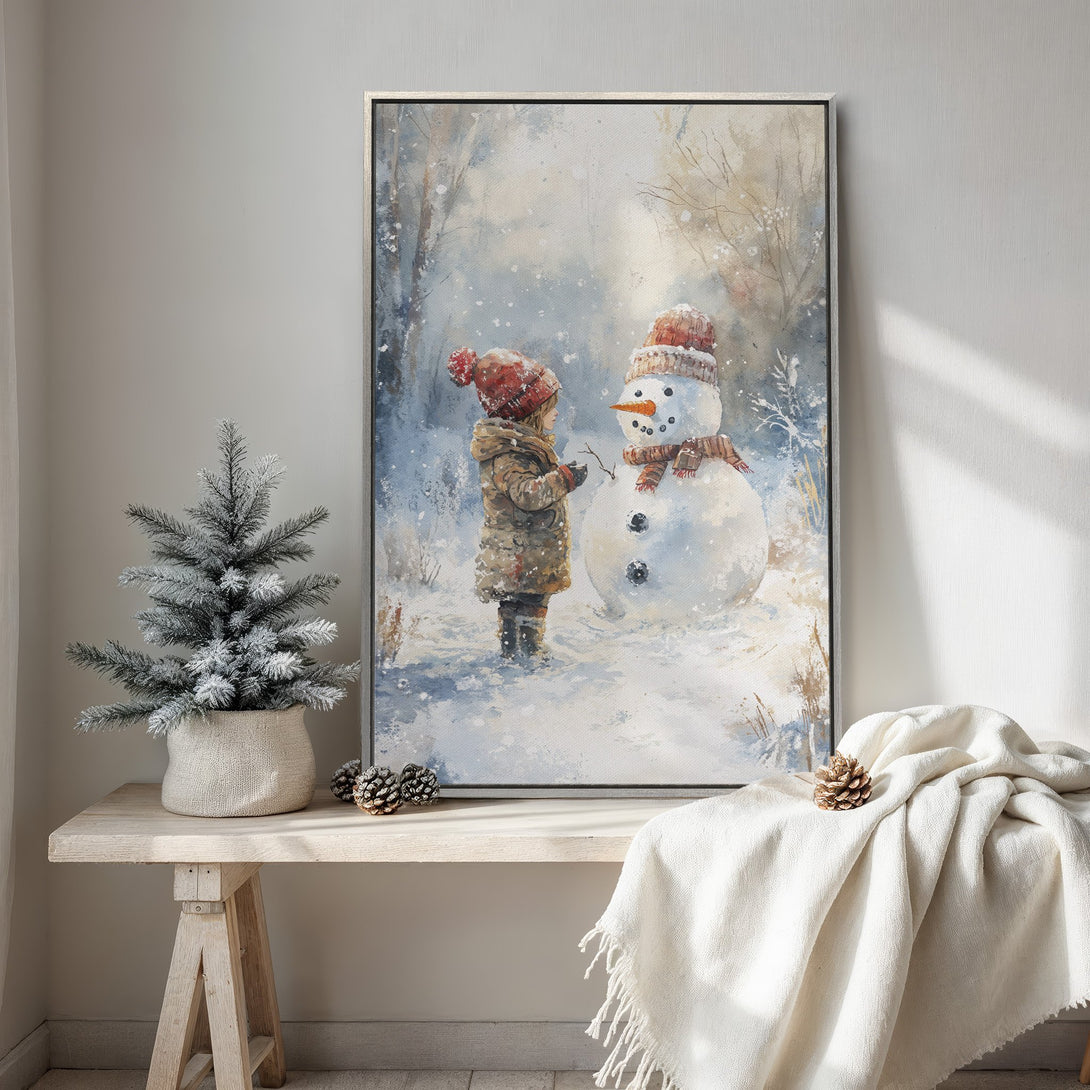 Framed Wall Art: Watercolor painting of a child building a snowman in a snowy forest. Soft blues, whites, and reds create a cozy winter scene. Perfect for holiday decor!