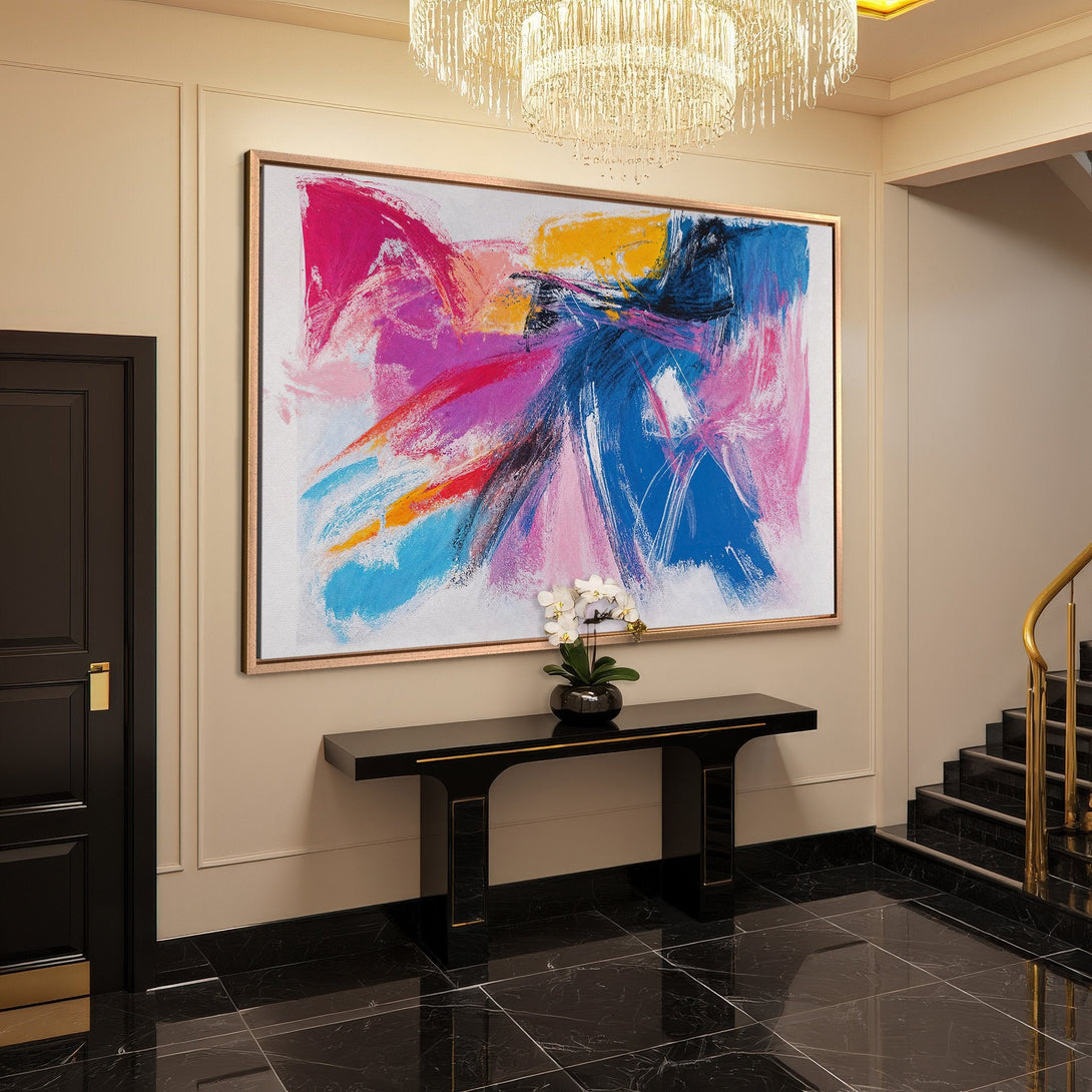 Framed Wall Art: Abstract expressionist canvas print with vibrant pink, blue, and yellow brushstrokes. Modern art for a stylish interior.