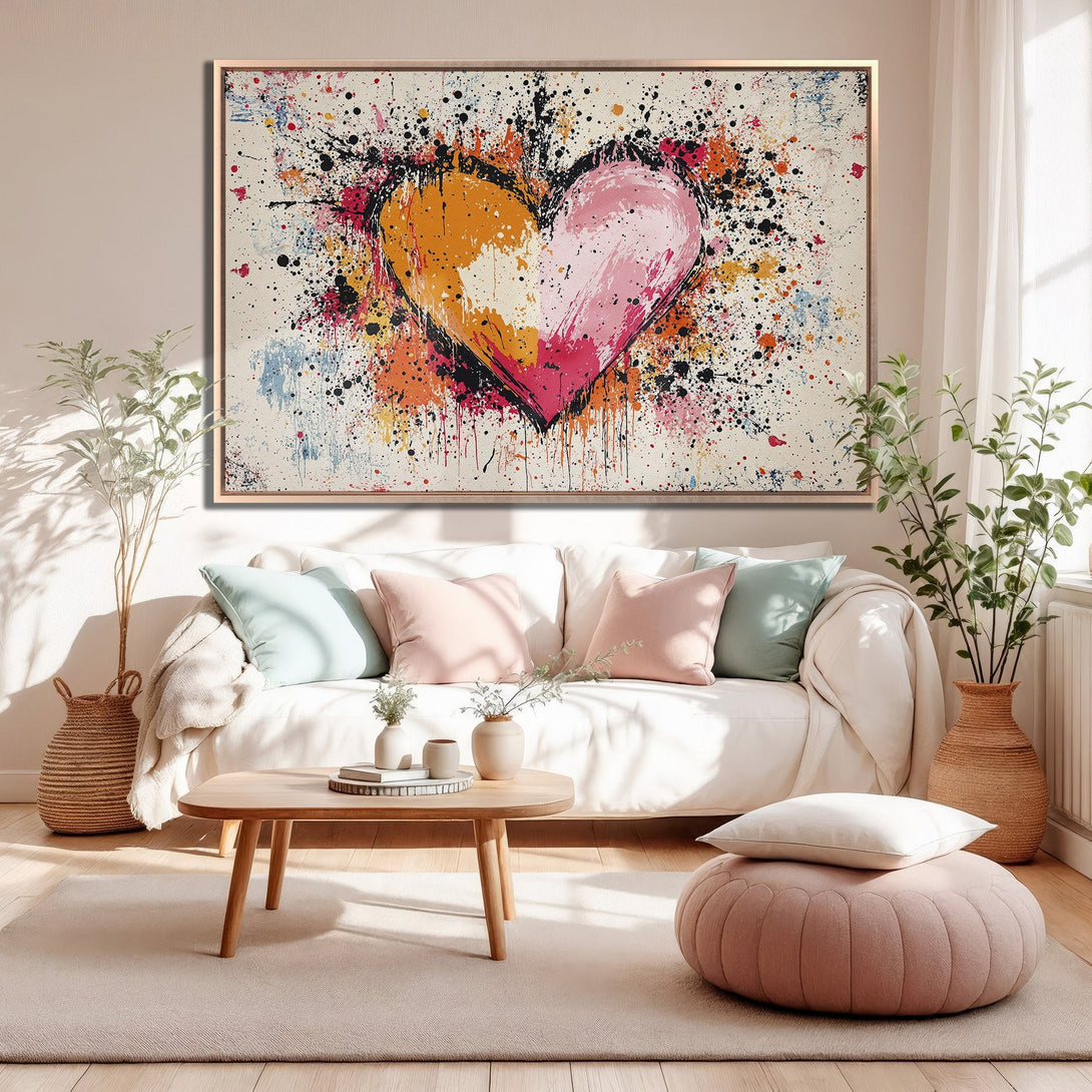 Framed Wall Art: Abstract heart canvas print with vibrant pink, orange, and black splatters. Modern art for a stylish living room.