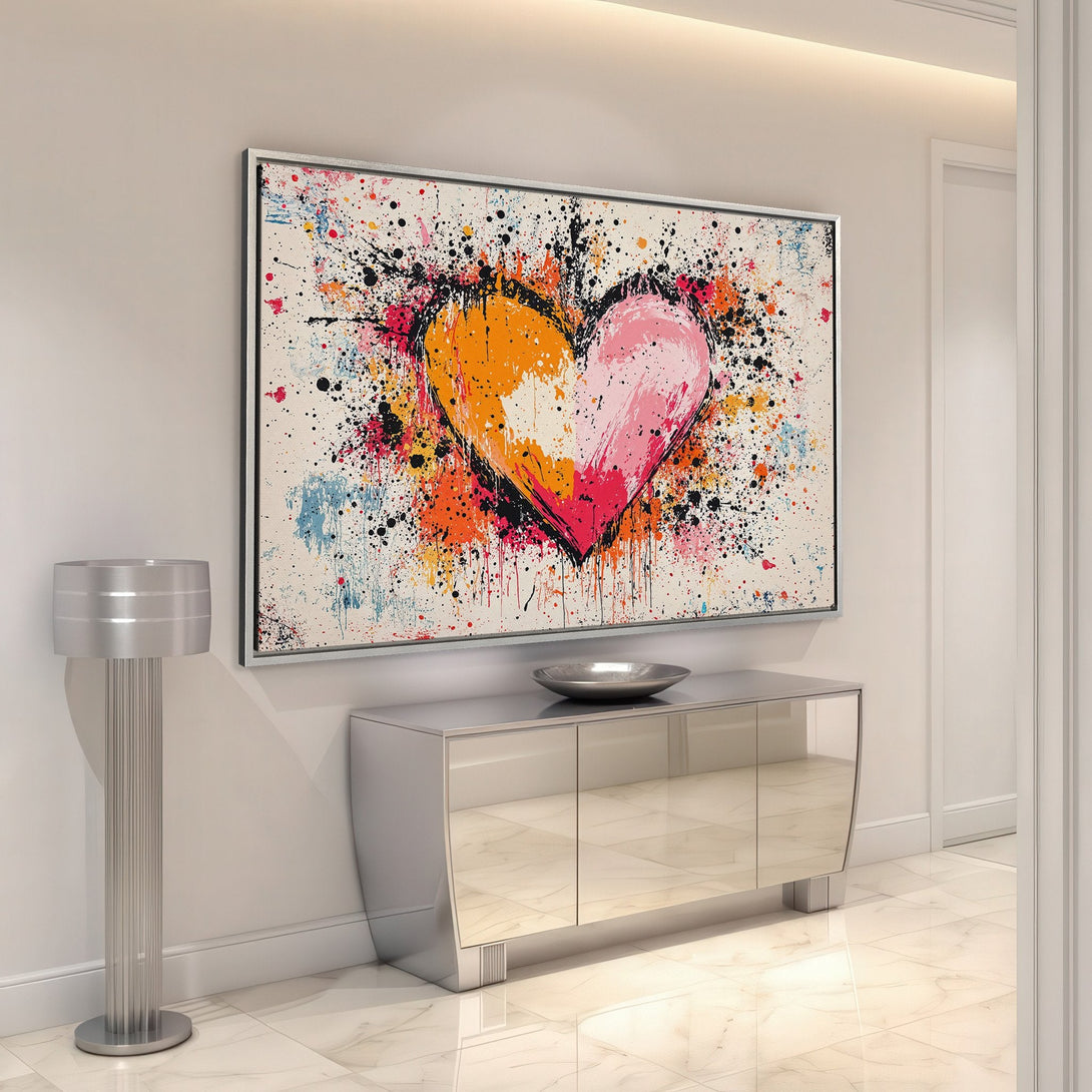 Framed Wall Art: Abstract heart canvas print with vibrant orange, pink, and black paint splatter. Modern art for a stylish home.