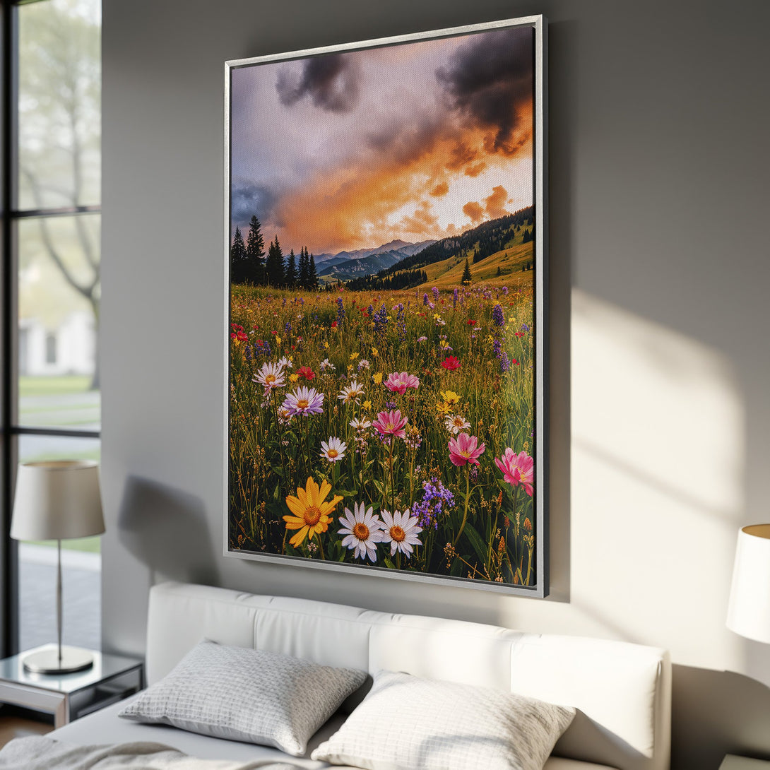 Framed Wall Art: Vibrant landscape canvas print of a wildflower meadow under a dramatic sunset. Warm orange, yellow, and pink hues bring nature indoors.