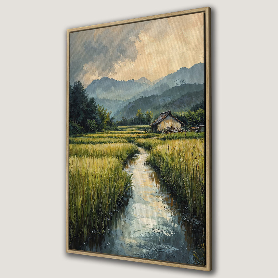 Framed Wall Art featuring a serene landscape painting with a stream, fields, and mountains. Warm yellow, green, and blue color palette. Perfect for home decor.