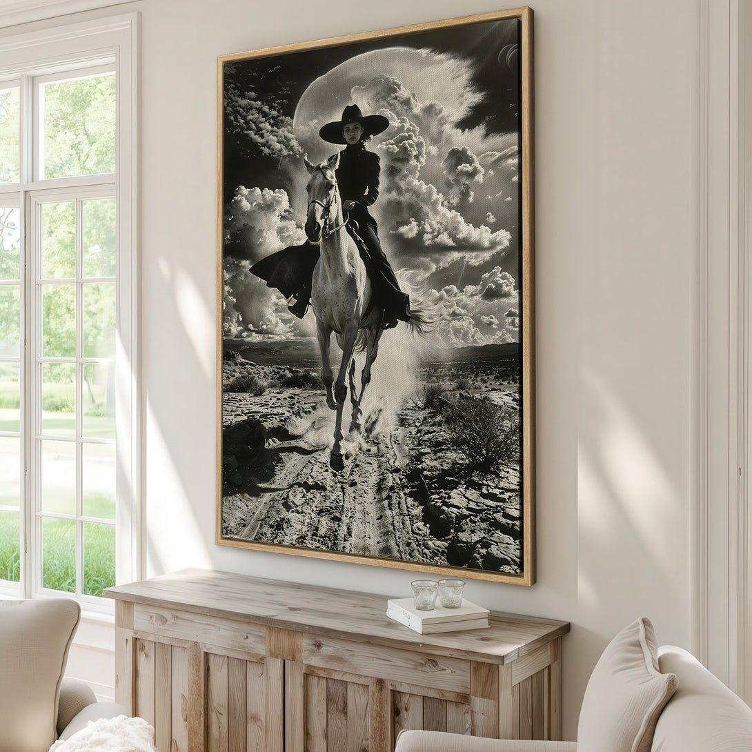 Framed Wall Art: Dramatic black and white print of a cowgirl on horseback against a cloudy sky. Perfect statement piece for modern or rustic decor.