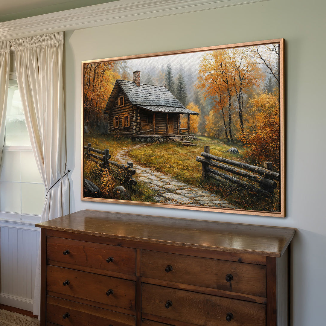 Framed Wall Art featuring a rustic cabin in an autumn forest. Warm, inviting color palette with golds, oranges, and browns. Perfect for cozy decor.