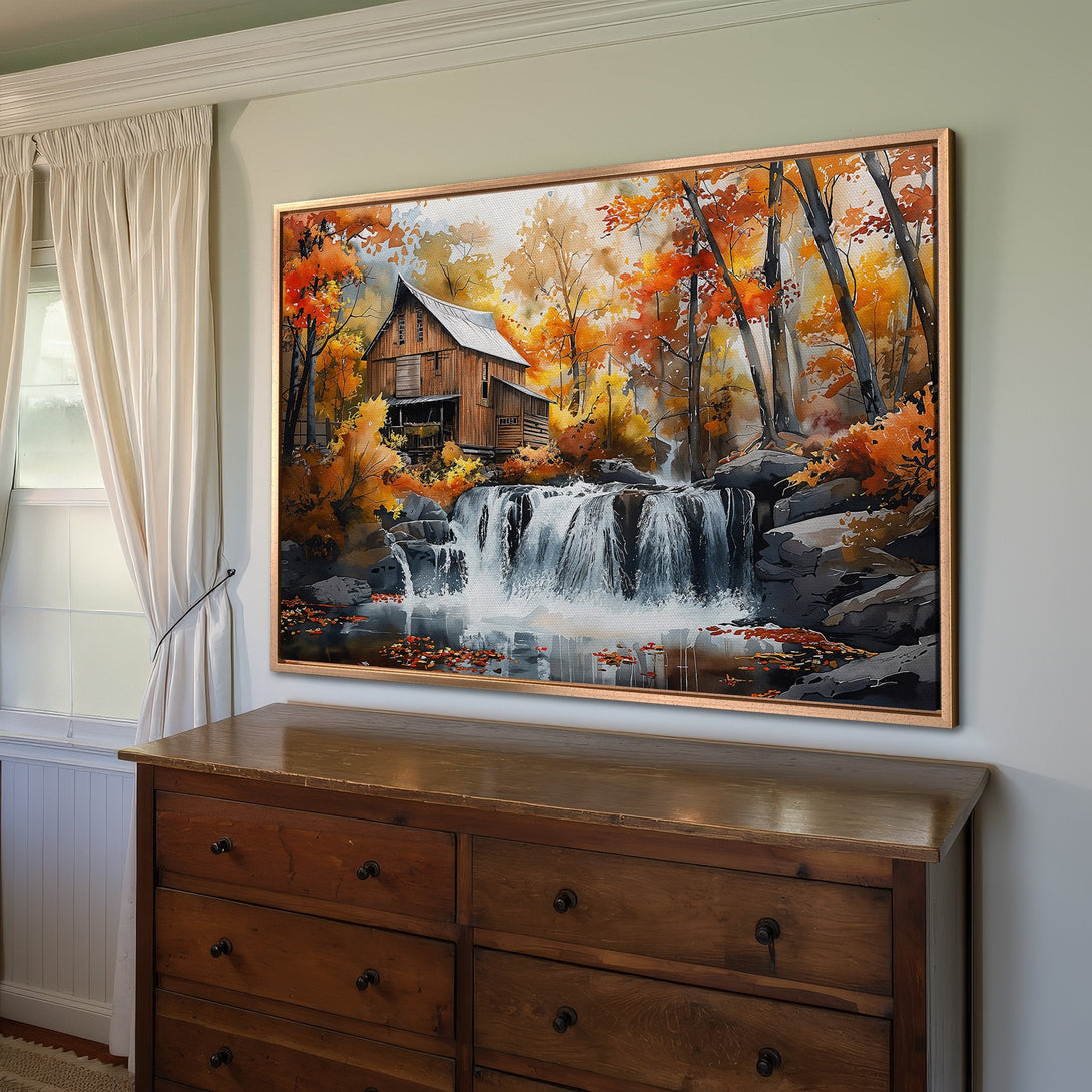 Framed Wall Art: Watercolor painting of a waterfall and autumn trees. Warm orange and yellow hues create a cozy, inviting atmosphere. Perfect for home decor!