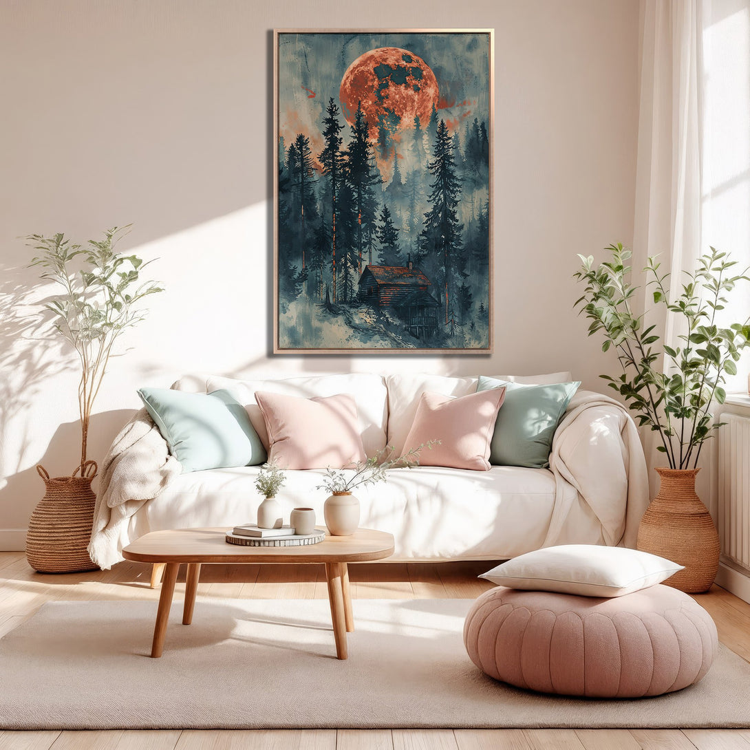Framed Wall Art of a cabin in the woods under a red moon. Moody, watercolor style with a teal and orange color palette. Perfect for cozy decor.