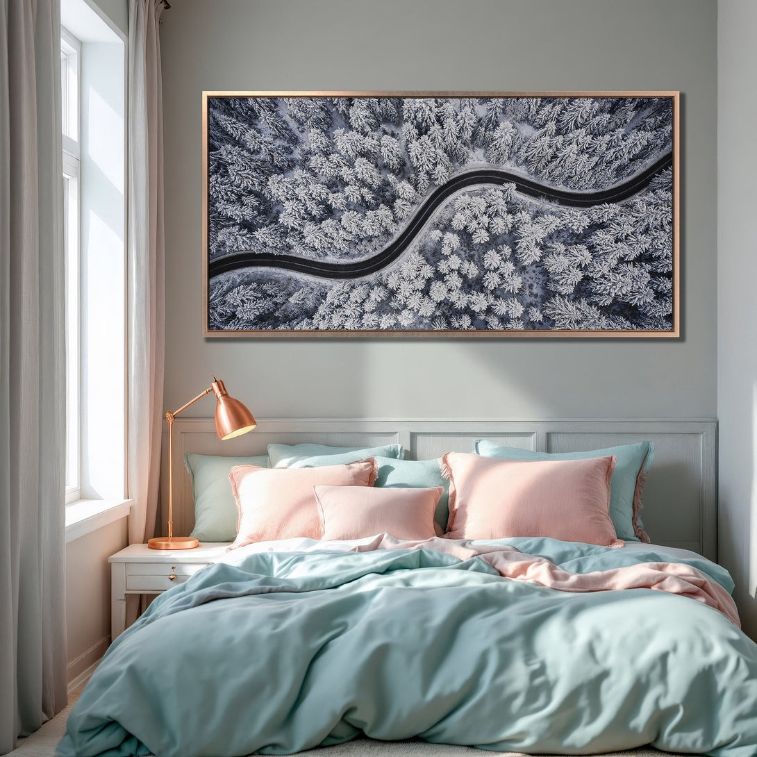 Framed Wall Art: Aerial view of snowy forest road in a bedroom. Cool blue, white, and gray tones create a serene, modern aesthetic. Perfect for home decor.