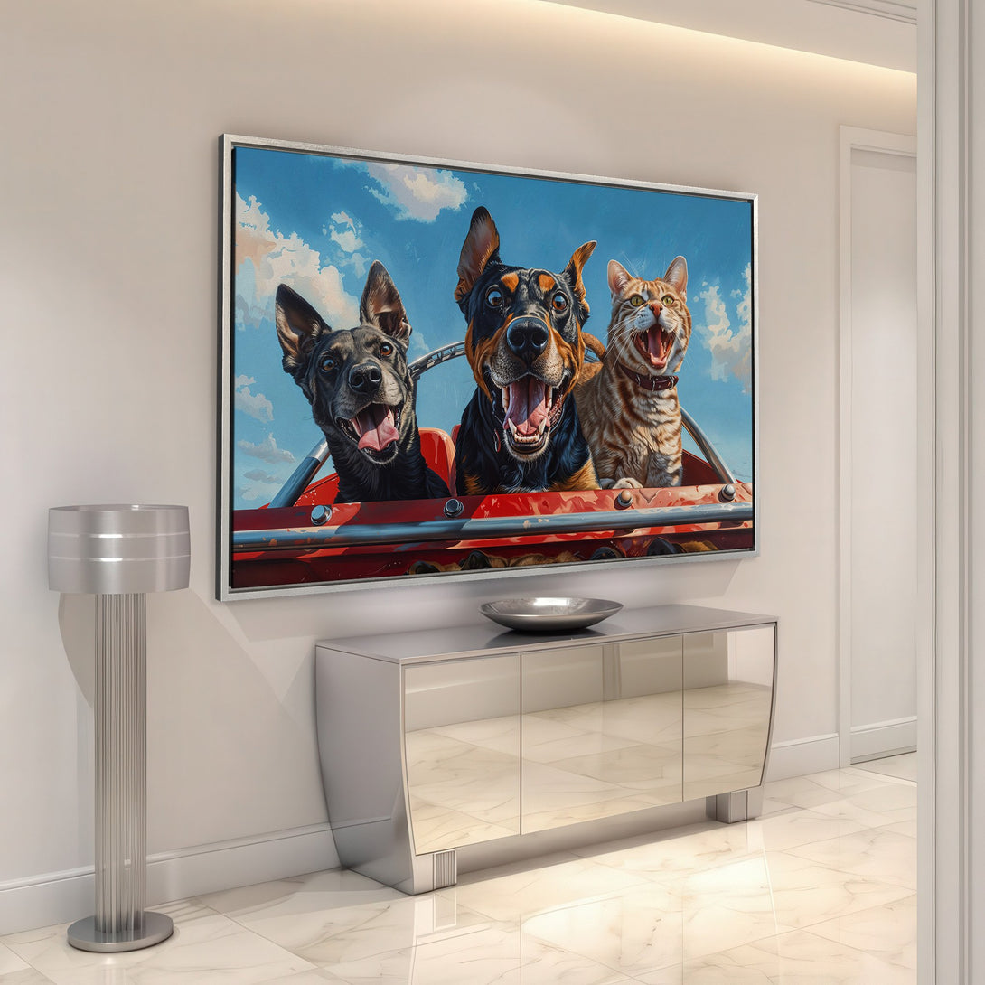Framed Wall Art featuring dogs and a cat in a red car, vibrant blue sky background. Fun, colorful pet art for your home.
