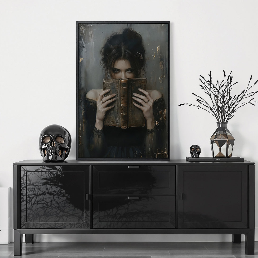 Framed Wall Art featuring a mysterious woman with a book. Moody, dark color palette with gold accents. Perfect for adding a touch of elegance to your home.