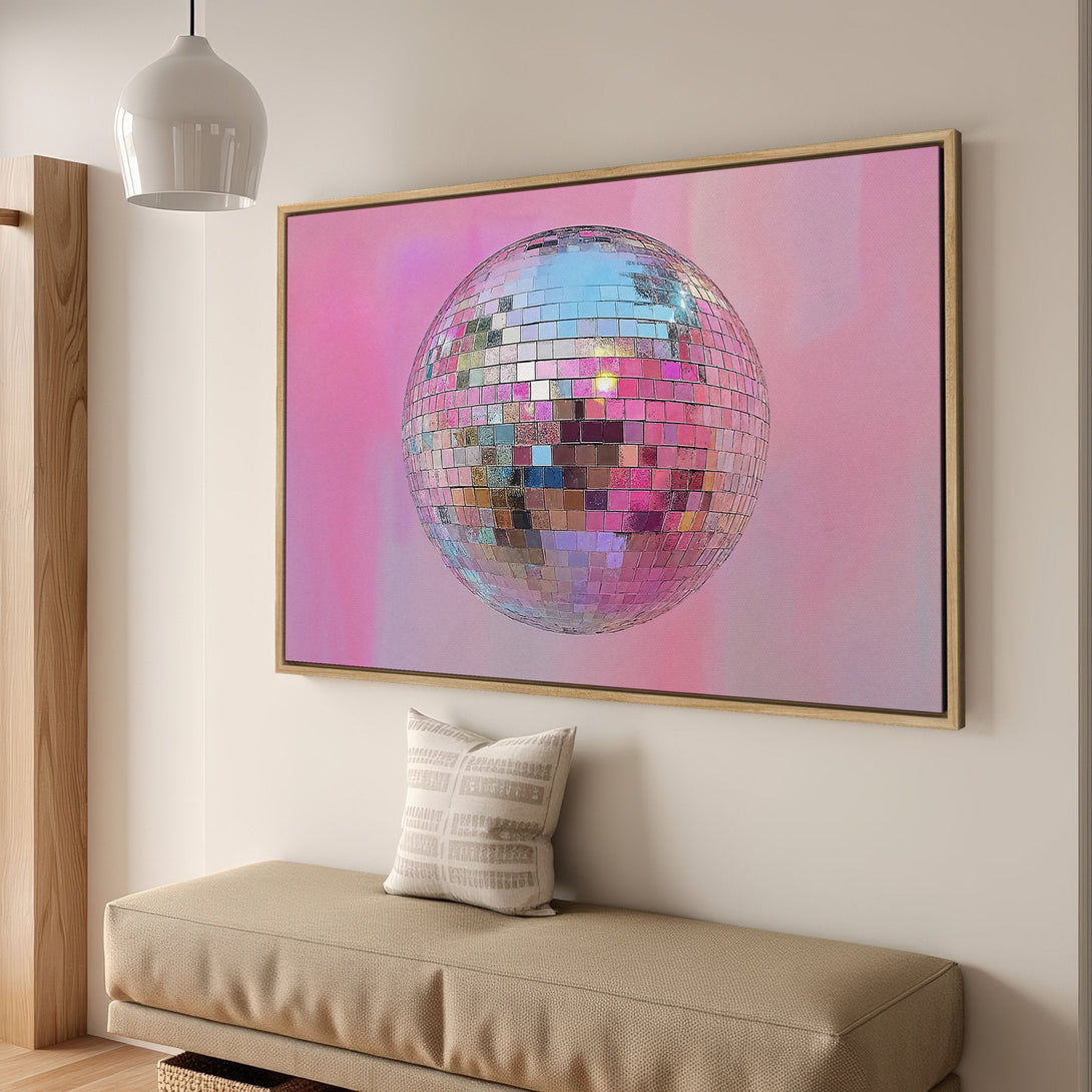 Framed Wall Art featuring a disco ball against a pink background. Modern, vibrant art with a retro aesthetic. Pink and silver color palette.