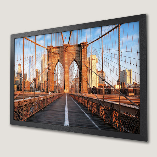 Framed Poster of Brooklyn Bridge at sunset. Photo art in warm orange and blue tones, capturing iconic architecture. Perfect wall decor.