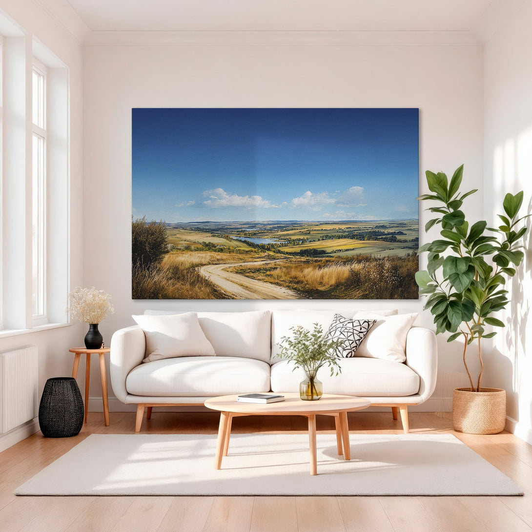 Framed Wall Art: Landscape Canvas Print in a gold frame, featuring a scenic landscape with blue sky, golden fields, and a winding road. Warm, inviting color palette.