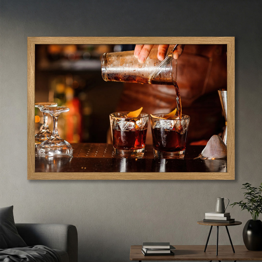 Framed Poster featuring a cocktail being poured, warm tones, and a stylish bar scene. Perfect wall art for your home bar!