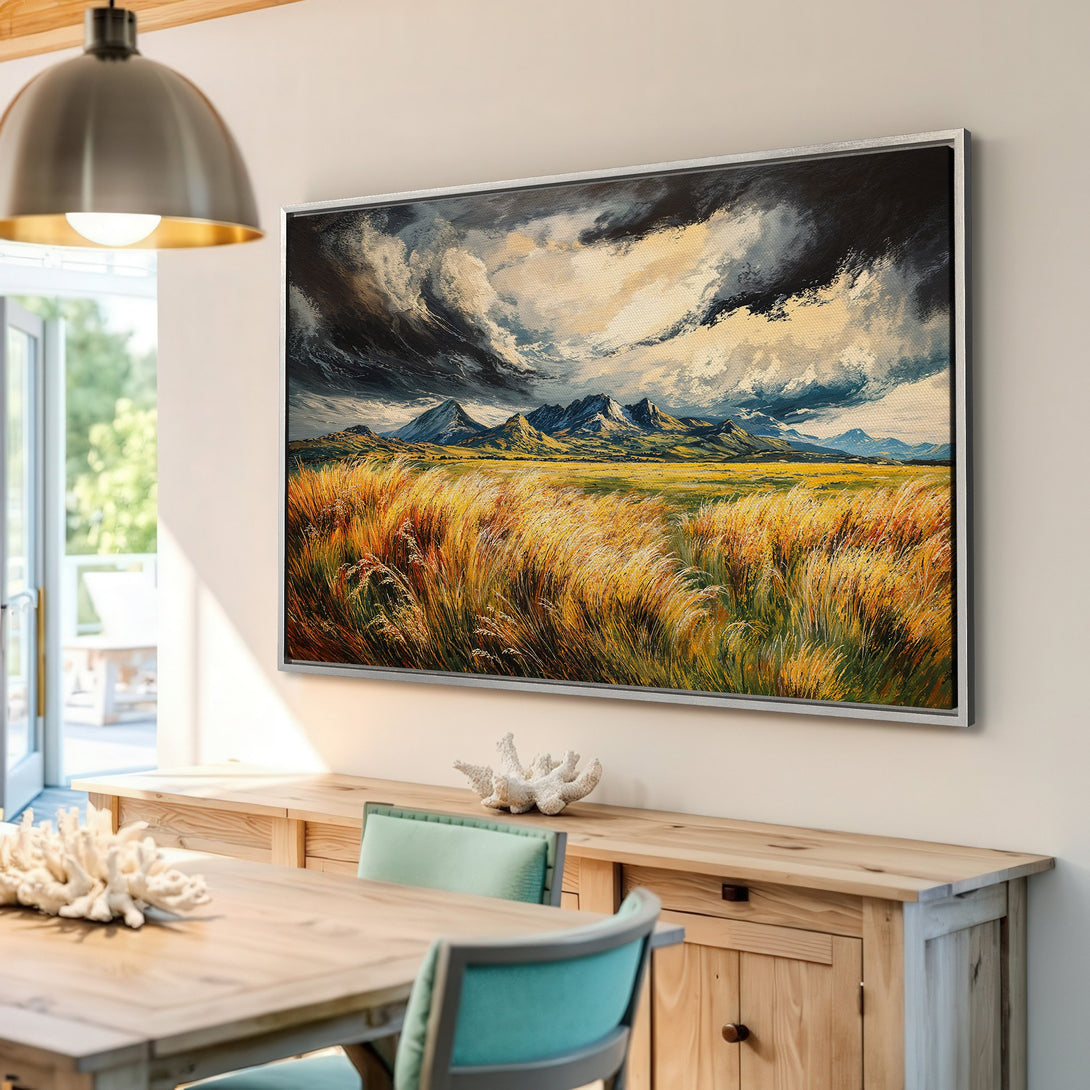 Framed Wall Art: Dramatic landscape Canvas Print with mountains and fields in warm yellow, blue, and gray tones, perfect for living room decor.