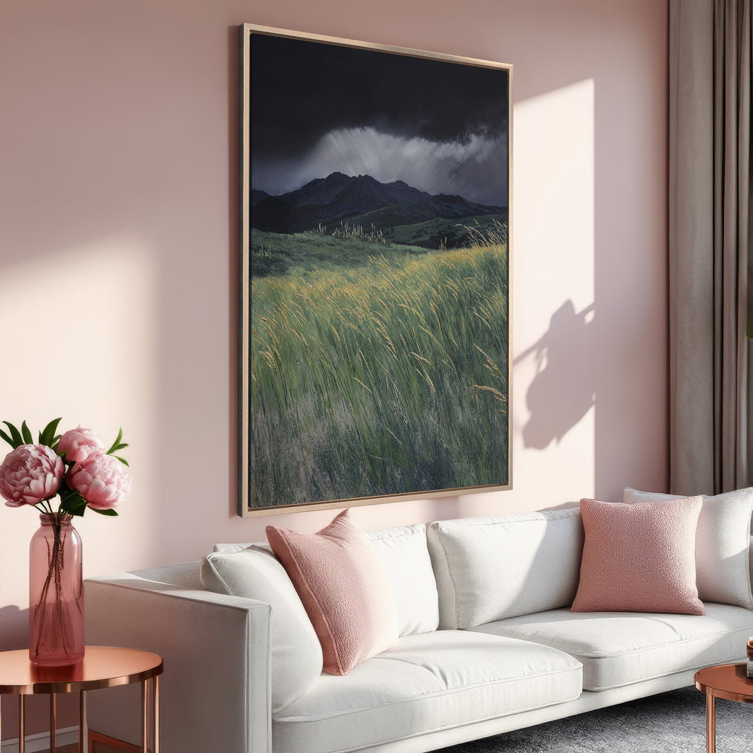 Framed Wall Art: Dramatic landscape Canvas Print with moody mountains & green field, displayed in a stylish interior with a blush & neutral color palette.
