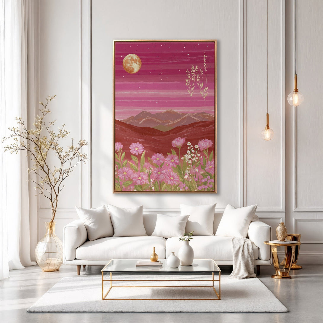 Framed Wall Art featuring a pink landscape with flowers, moon, and mountains. A beautiful canvas print in a modern interior with a pink and gold color palette.