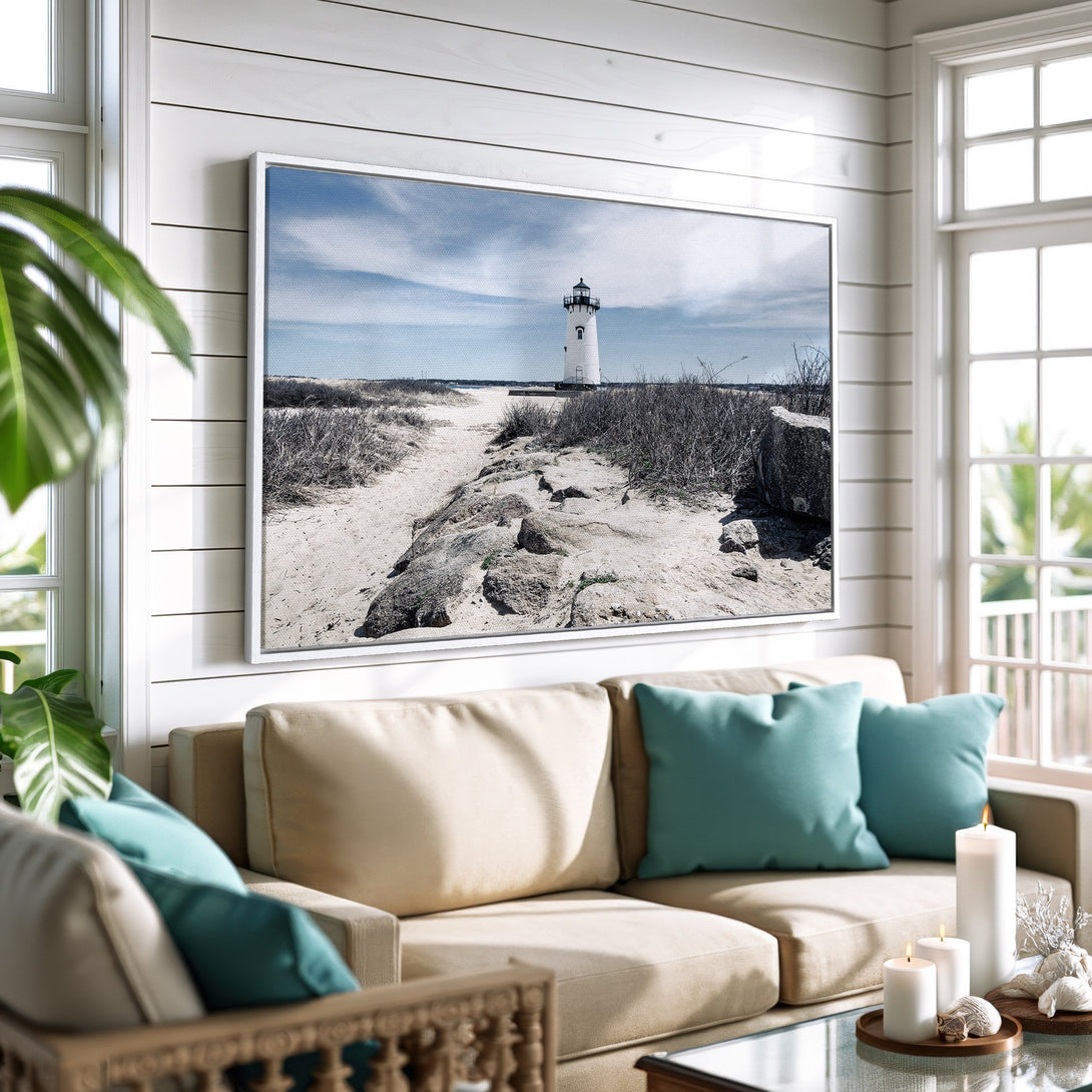 Framed Wall Art: Coastal lighthouse canvas print in a serene interior. Features a neutral color palette with blue accents, perfect for beach house decor.