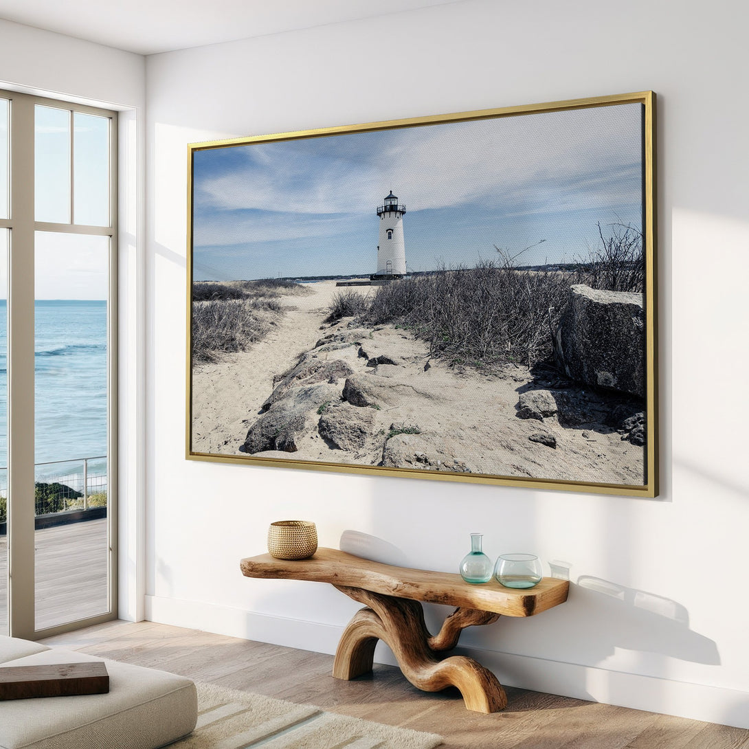 Canvas Print of a lighthouse on a sandy path. Coastal style art with a neutral, blue, and white color palette. Perfect for adding serene vibes to your space.