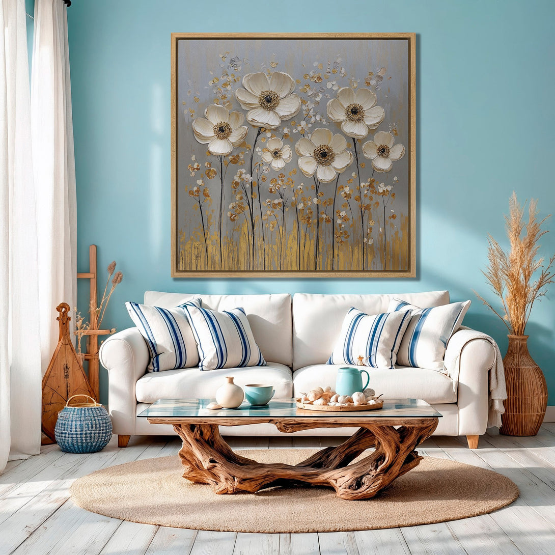 Framed Wall Art featuring elegant white floral painting with gold accents. Coastal style decor in a living room with blue and neutral color palette.
