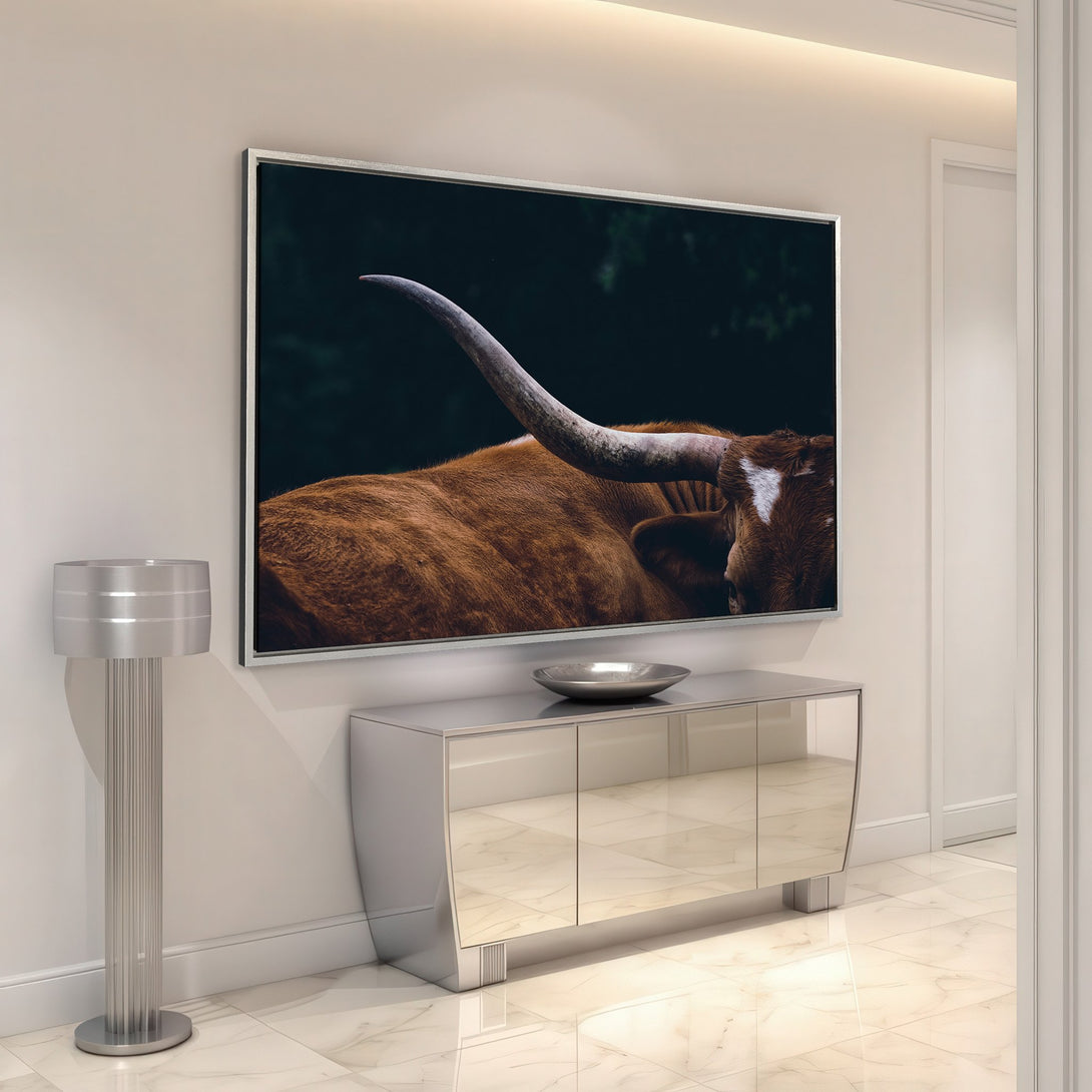 Framed Wall Art featuring a close-up of a longhorn bull in a dark, moody style. Earthy tones of brown and green create a rustic, yet modern look.