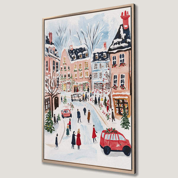 Framed Wall Art: Watercolor painting of a snowy European street scene. Features a warm, festive color palette with reds, pinks, and blues, perfect for holiday decor.