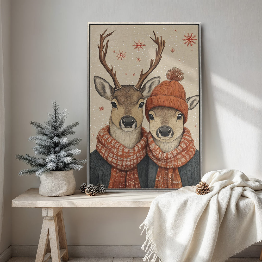 Framed Wall Art featuring two deer in winter attire, cozy and whimsical style. Warm neutral color palette with pops of orange and red. Perfect for holiday decor.